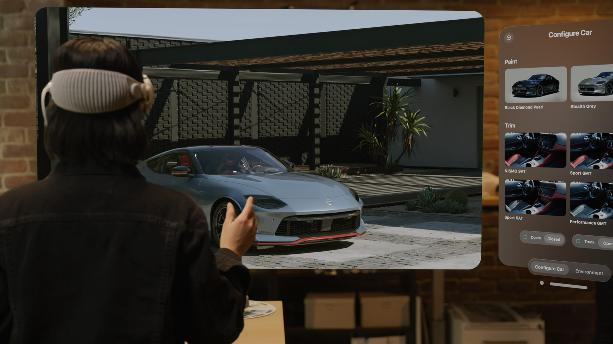 A person using a hand gesture to interact with a full-size 3D car model on Apple Vision Pro