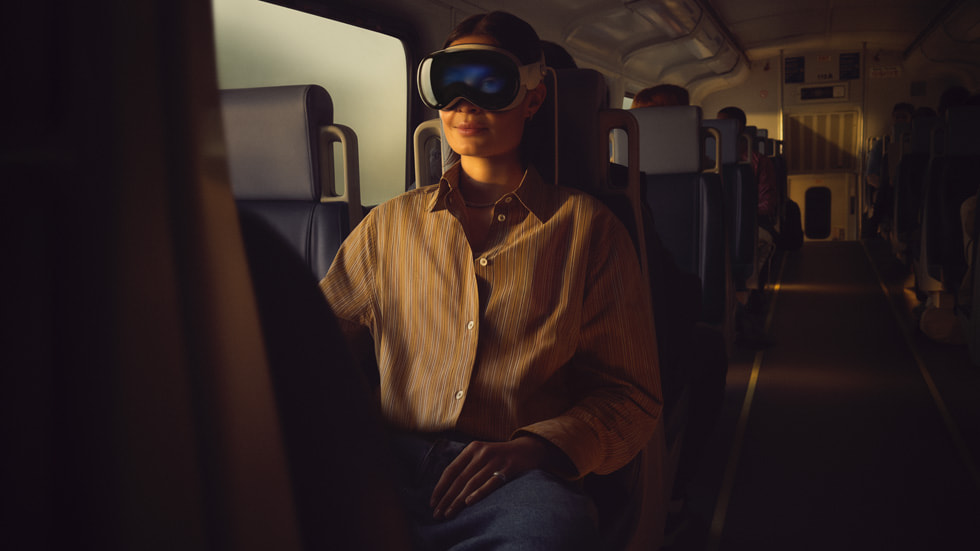 A traveler uses Apple Vision Pro aboard a train