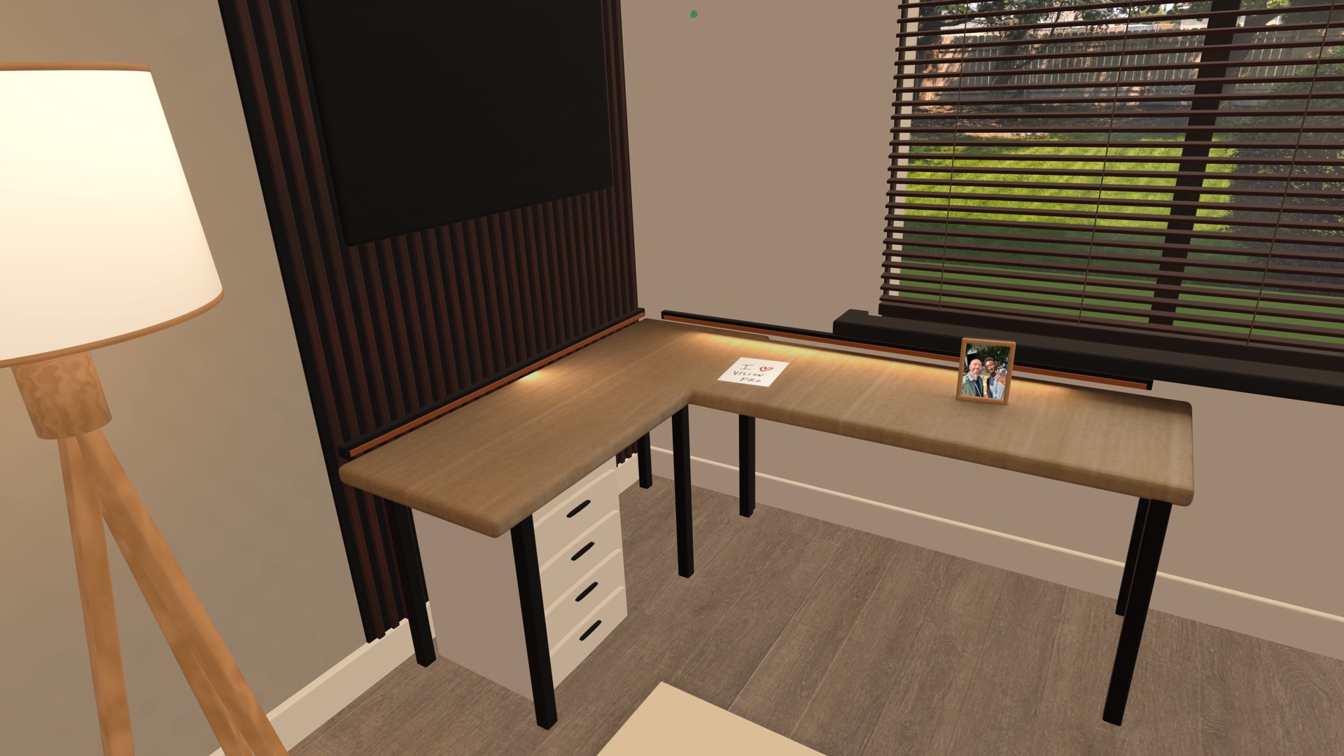 A real-size L-shaped wood desk with warm edge lighting, a framed photo, and a handwritten I love Vision Pro note inside the Spatial Insider studio