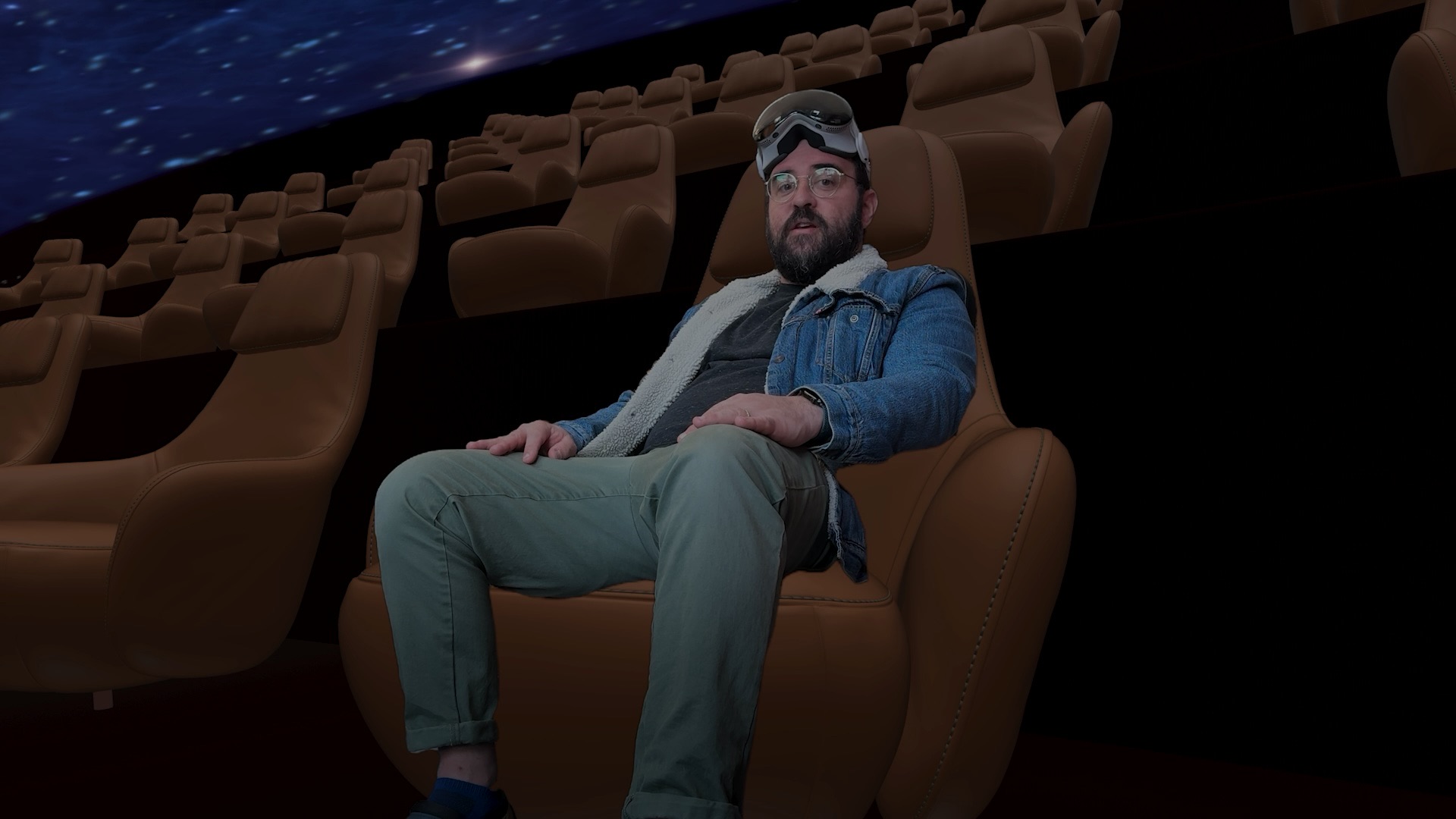 Adam Lisagor seated inside Theater’s virtual planetarium with an Apple Vision Pro resting on his forehead