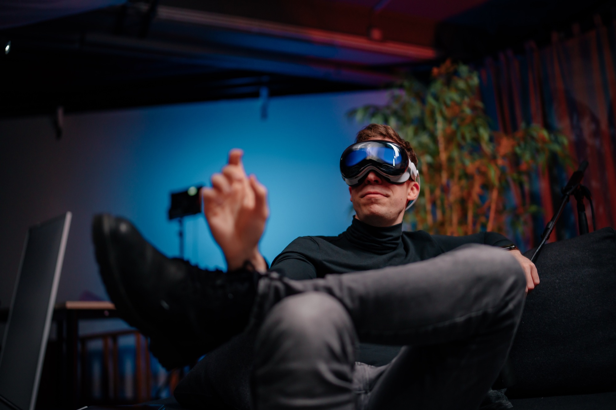 Phil Traut wearing an Apple Vision Pro and making a pinch gesture in a colorful studio