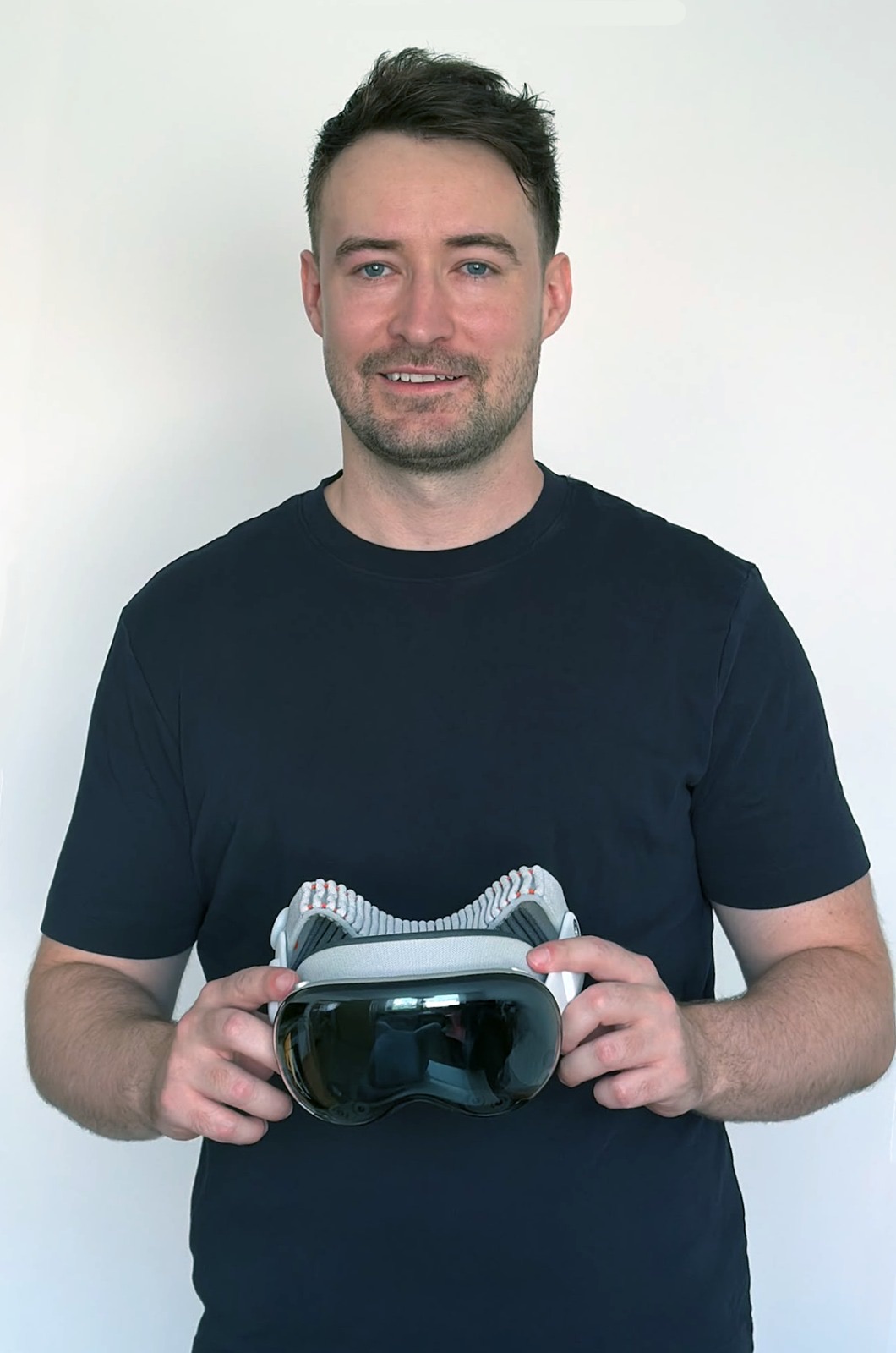 Tomas Cupal holding an Apple Vision Pro against a light background
