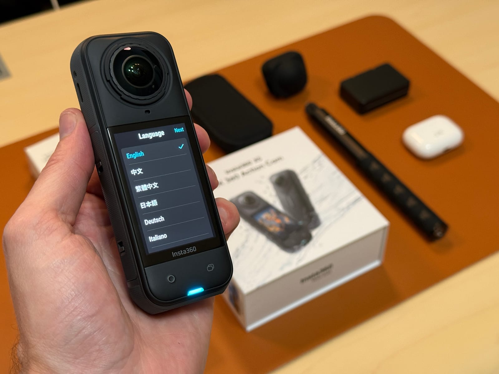 An Insta360 camera held above a hands-on testing table
