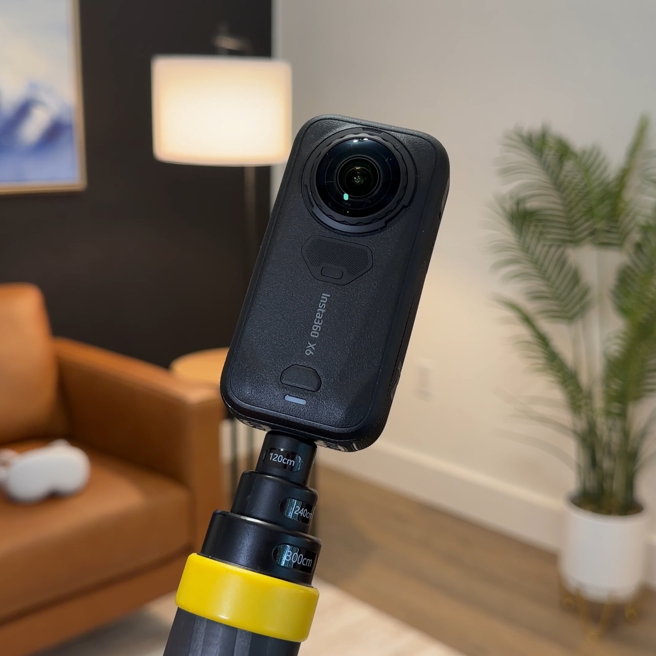 An Insta360 X6 camera on a selfie stick in our studio