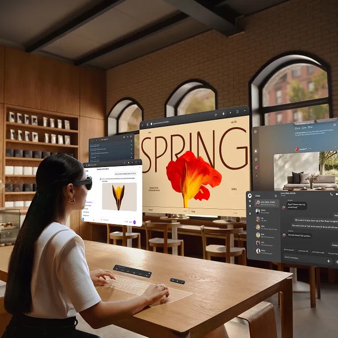 Meta promotional visualization of a glasses wearer using floating app windows and a virtual keyboard at a table.