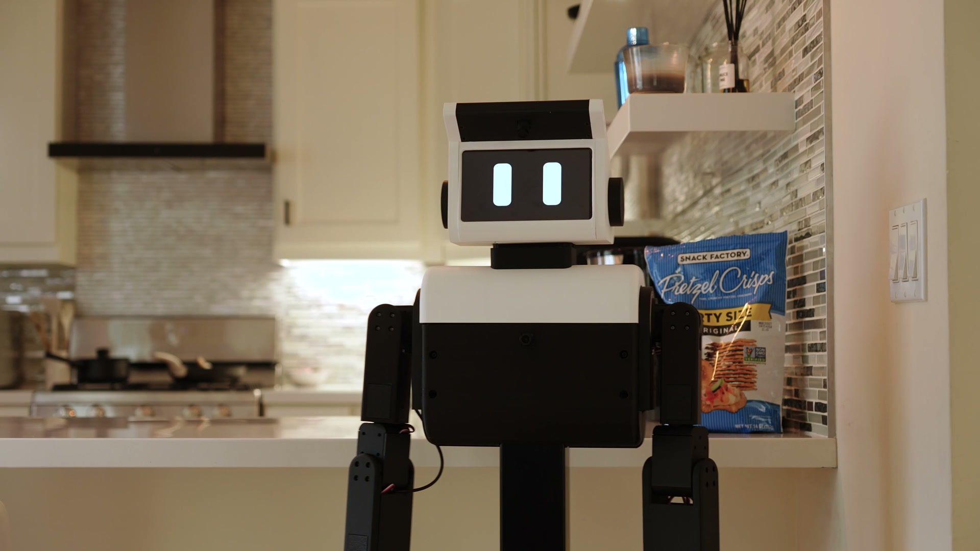 Nori A3 home robot carrying a bag of pretzels in a kitchen