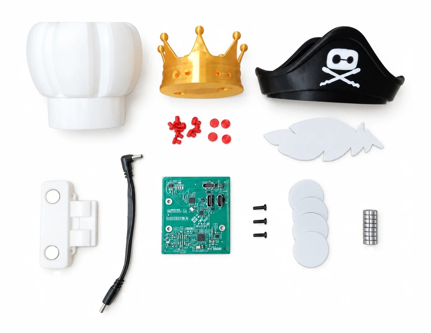The Reachy Mini NFC kit with chef, crown, and pirate hats, a reader board, four tags, and magnets.