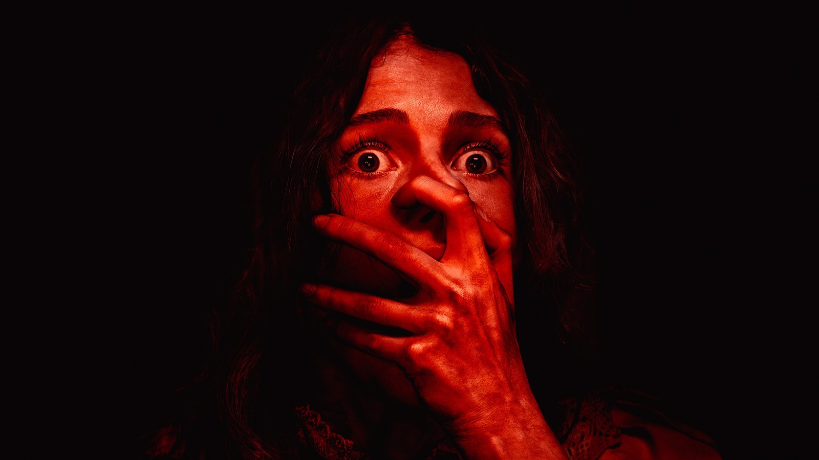 A frightened woman lit in red in Apple’s official artwork for Remnants