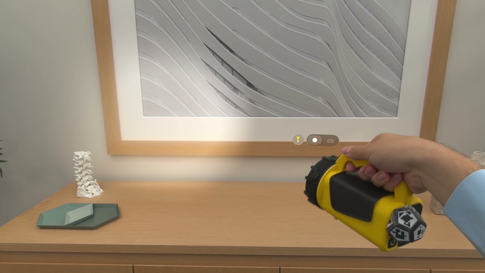 A flashlight with a printed marker aims a virtual light at framed artwork in Apple’s Vision Pro demo