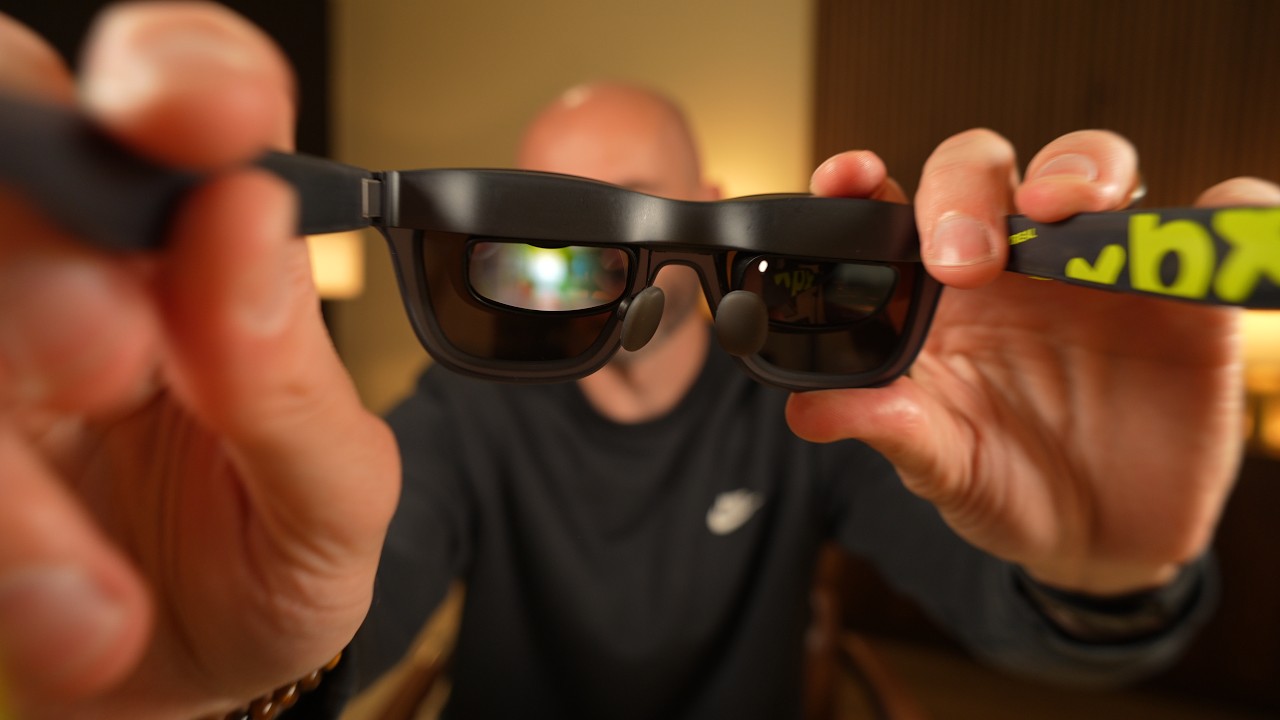 Justin Ryan holds XREAL xbx display glasses close to the camera, showing the lenses and nose pads